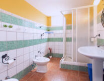 a green tiled shower and sink